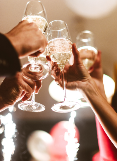 Persone brindano con calici di champagne durante una festa.