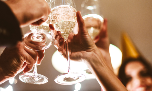 Persone brindano con calici di champagne durante una festa.